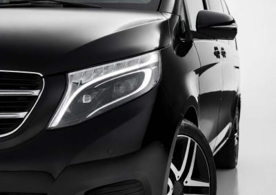 Luksuzni mercedes kombi v klase iz flote pds limo servisa, crne boje slikan sa prednje bočne strane na sivoj studijskoj pozadini